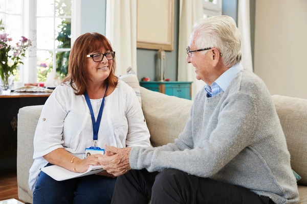 Une assistante sociale discute avec un couple de seniors