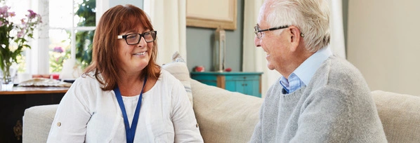 Une assistante sociale discute avec un couple de seniors